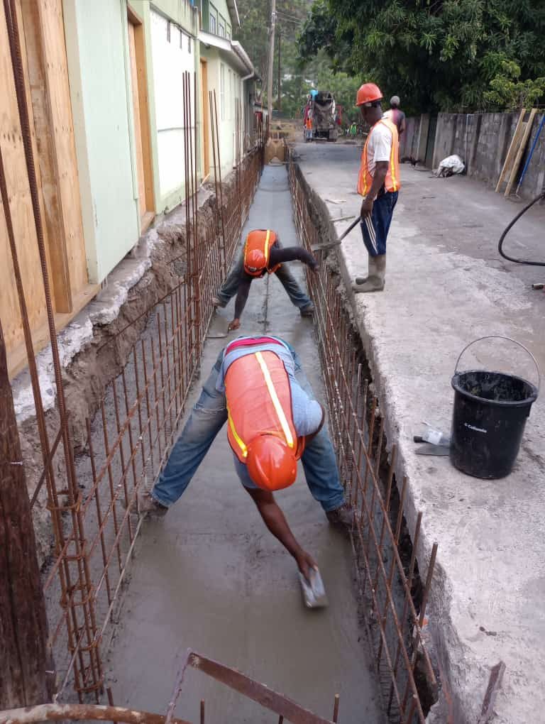 Crew placing concrete in a drainage channel